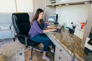 person sitting at desk while working on a laptop